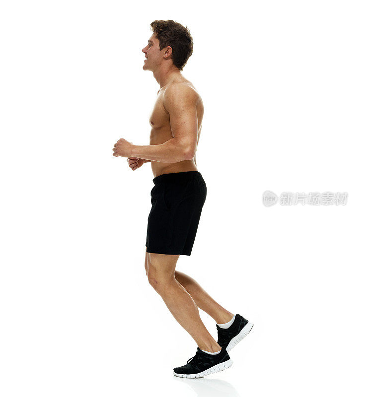 全身/一人/侧视图/侧视图20-29岁的成年人英俊的人棕色头发/短发高加索男性/年轻男子跑步/慢跑在白色背景前穿着短裤/跑步短裤/运动鞋